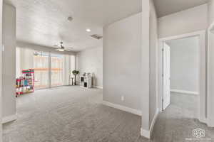 Loft area/living room featuring a textured ceiling, ceiling fan, and carpet flooring