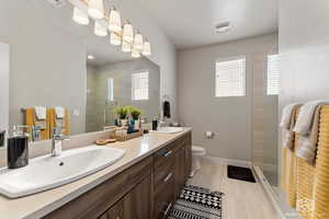 Primary Bathroom featuring tiled shower, vanity, toilet, and tile patterned floors