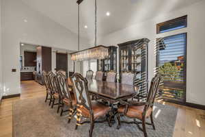 Dining space featuring high vaulted ceiling and light hardwood / wood-style flooring