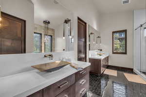 Bathroom featuring a shower with door, vanity, and tile patterned flooring