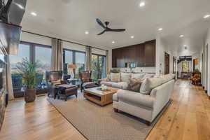 Living room with light hardwood / wood-style flooring and ceiling fan