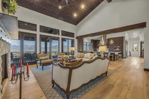 Living room featuring a mountain view, high vaulted ceiling, ceiling fan, and plenty of natural light