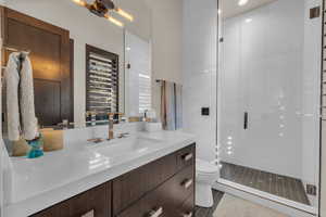 Bathroom with tile patterned flooring, vanity, an enclosed shower, and toilet