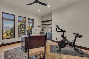 Office space with light hardwood / wood-style floors and ceiling fan