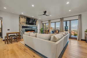 Living room featuring ceiling fan, light hardwood / wood-style floors, plenty of natural light, and a fireplace