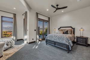 Bedroom with dark colored carpet, ceiling fan, and access to exterior