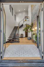 Entryway with hardwood / wood-style floors and a towering ceiling