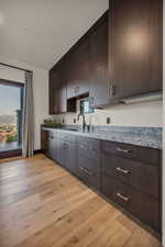 Kitchen featuring dark brown cabinets, light hardwood / wood-style floors, and sink