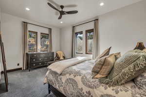 Bedroom with dark colored carpet and ceiling fan