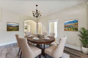 VIRTUALLY STAGED - Dining space with dark hardwood / wood-style flooring and a notable chandelier - This space could be used for dining or living.