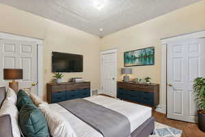 VIRTUALLY STAGED - Bedroom with carpet and a textured ceiling