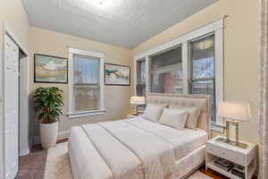 VIRTUALLY STAGED -Bedroom featuring a closet and a textured ceiling