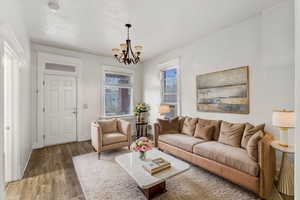 Living area featuring baseboards, a chandelier, and wood finished floors - This space could be used for dining or living, see dining photo same space