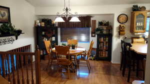 Dining space with hardwood / wood-style floors and a chandelier