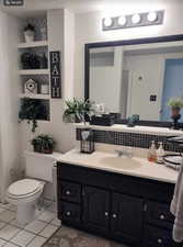 Bathroom featuring vanity, toilet, an enclosed shower, a textured ceiling, and tile patterned flooring