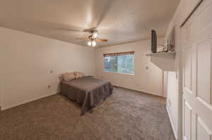 Bedroom featuring carpet flooring, ceiling fan, and a textured ceiling