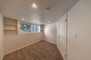 Unfurnished room with a textured ceiling and carpet floors