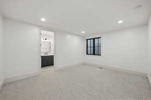 Empty room featuring recessed lighting, light carpet, baseboards, and a smoke detector