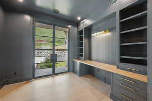 Mudroom featuring built in desk, french doors, built in shelves, light wood-style floors, and recessed lighting