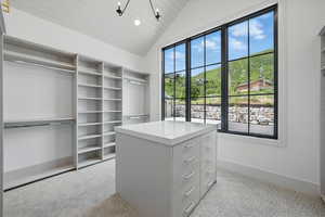 Spacious closet featuring carpet and vaulted ceiling