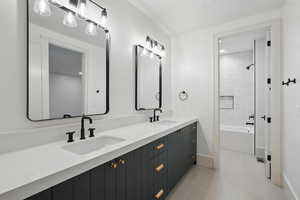 Bathroom featuring double vanity, baseboards, tub / shower combination, and tile patterned flooring