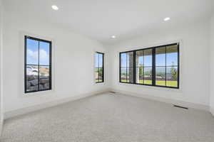 Carpeted empty room with plenty of natural light, recessed lighting, and baseboards