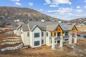 Rear view of property featuring a balcony and a mountain view