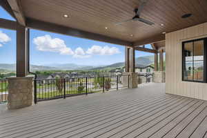 Deck with a mountain view, a ceiling fan, and a residential view