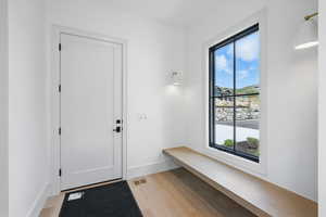 Mudroom featuring light wood-style floors and baseboards