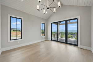 Spare room featuring healthy amount of natural light, wood finished floors, baseboards, a mountain view, and wood ceiling