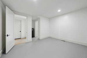 Empty room with recessed lighting, finished concrete floors, and baseboards
