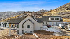 Rear view of house featuring a mountain view, a balcony, and a garage