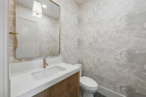 Half bathroom with vanity and toilet