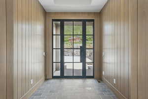 Doorway with wood walls and baseboards