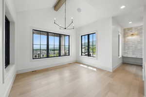 Spare room with light wood-style flooring, a chandelier, baseboards, and recessed lighting
