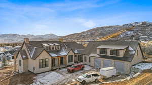 Snow covered property featuring a mountain view and a garage