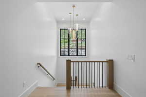 Stairway featuring baseboards, wood finished floors, and recessed lighting