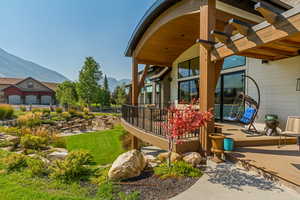 View of yard featuring a deck with mountain view and a patio area