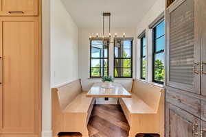 Dining area with a healthy amount of sunlight, a chandelier, and hardwood / wood-style flooring