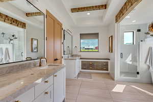 Master Bathroom featuring a tray ceiling, vanity, tile patterned flooring, and a shower with door