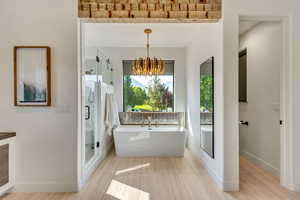 Master Bathroom with an inviting chandelier, decorative backsplash, and shower with separate bathtub