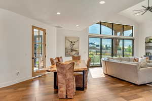 Dining space with lofted ceiling, wood-type flooring, and ceiling fan