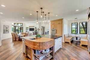 Kitchen featuring hardwood / wood-style flooring, an island with sink, sink, and double oven