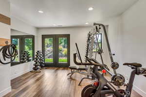 Exercise area featuring hardwood / wood-style flooring and french doors