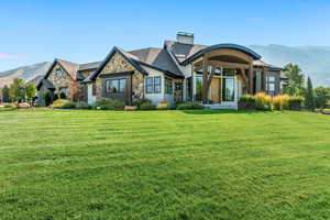 View of front facade with a mountain view and a front yard