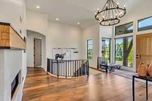 Entryway with high vaulted ceiling, wood-type flooring, and a notable chandelier