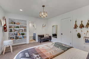 Carpeted bedroom with a chandelier and ensuite bathroom