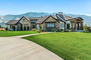 View of front of home with a mountain view and a front yard