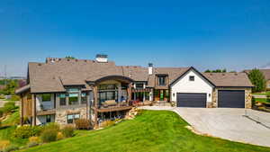 View of back of property with a balcony and a garage