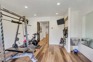 Exercise area with hardwood / wood-style flooring